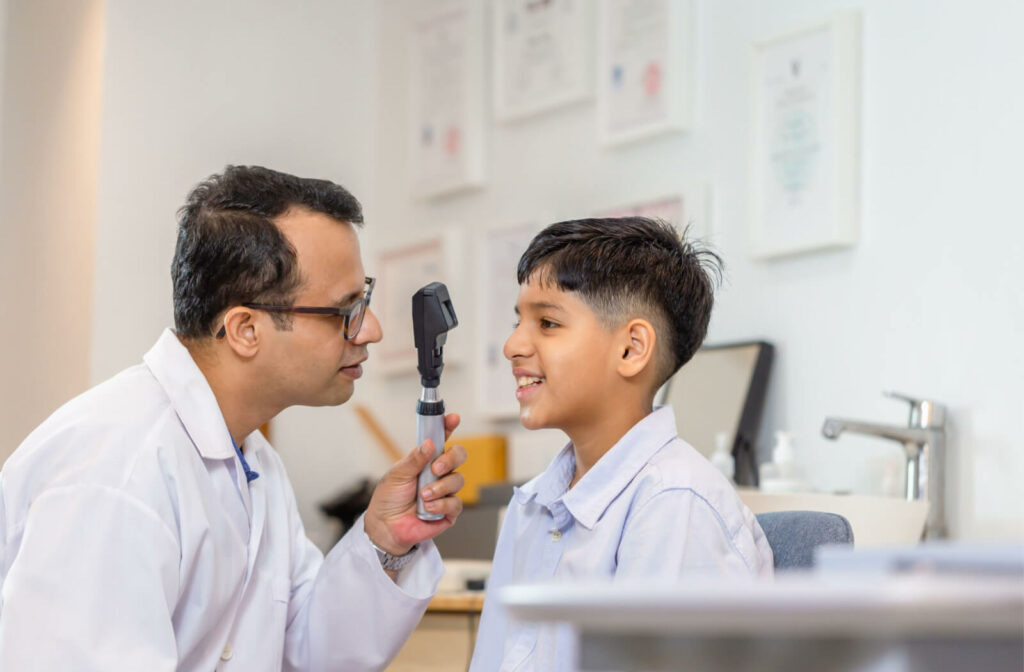 An eye doctor examining the health of a young child's eye during a routine eye exam