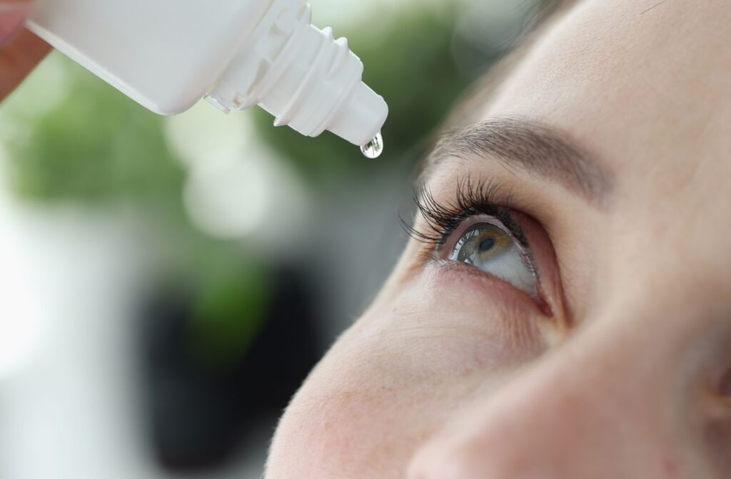 A closeup image of an individual dripping eye drops into their eyes