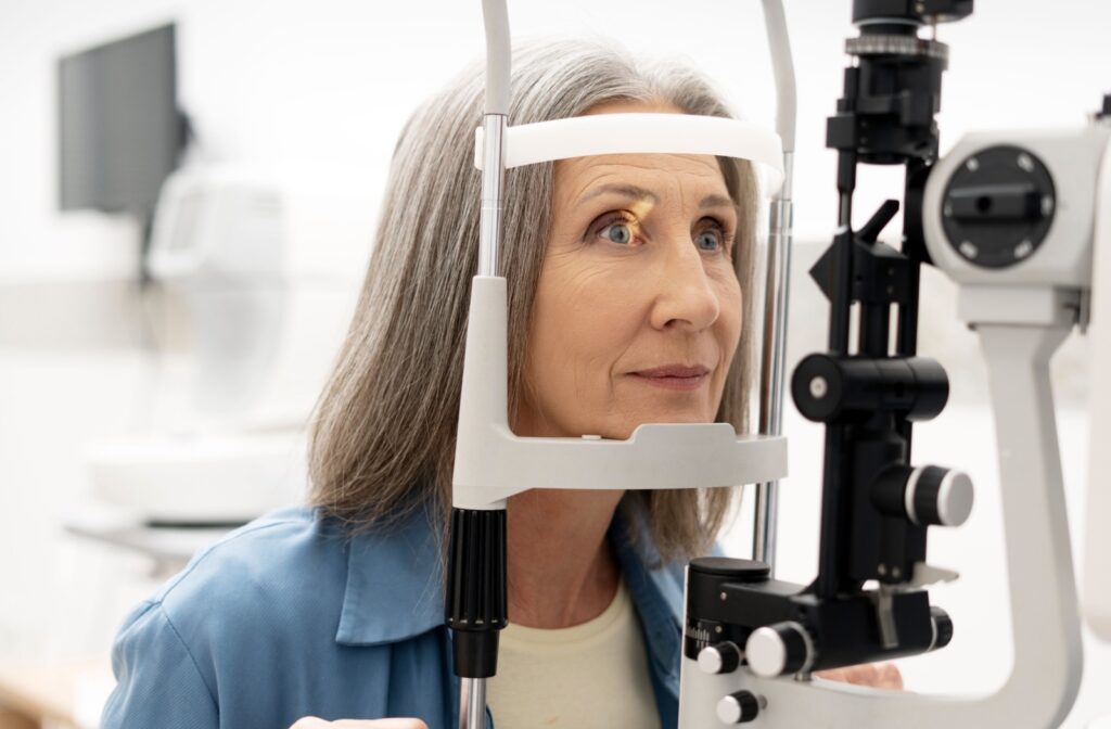 An older adult undergoing a slit lamp exam to check for macular degeneration during their routine eye exam.