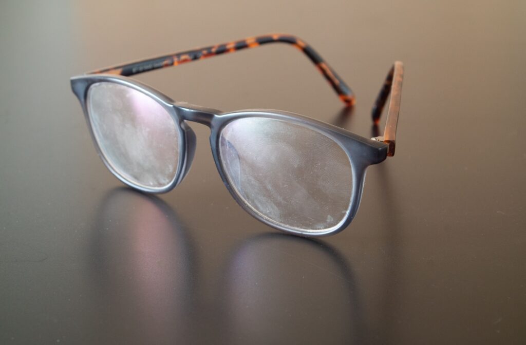 A pair of glasses with smudges and fingerprints on the lenses.