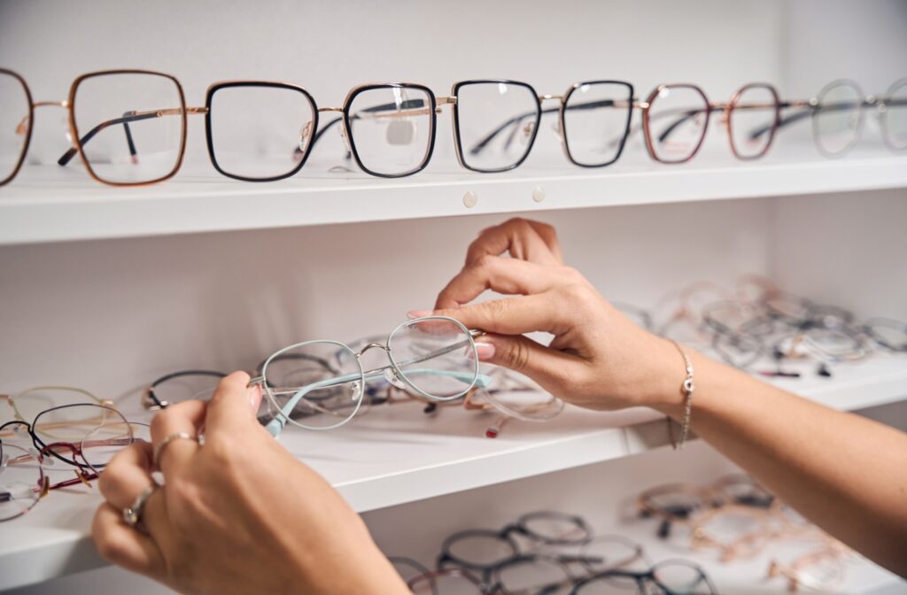 Hands selecting a new pair of glasses after getting their prescription updated from their optometrist.