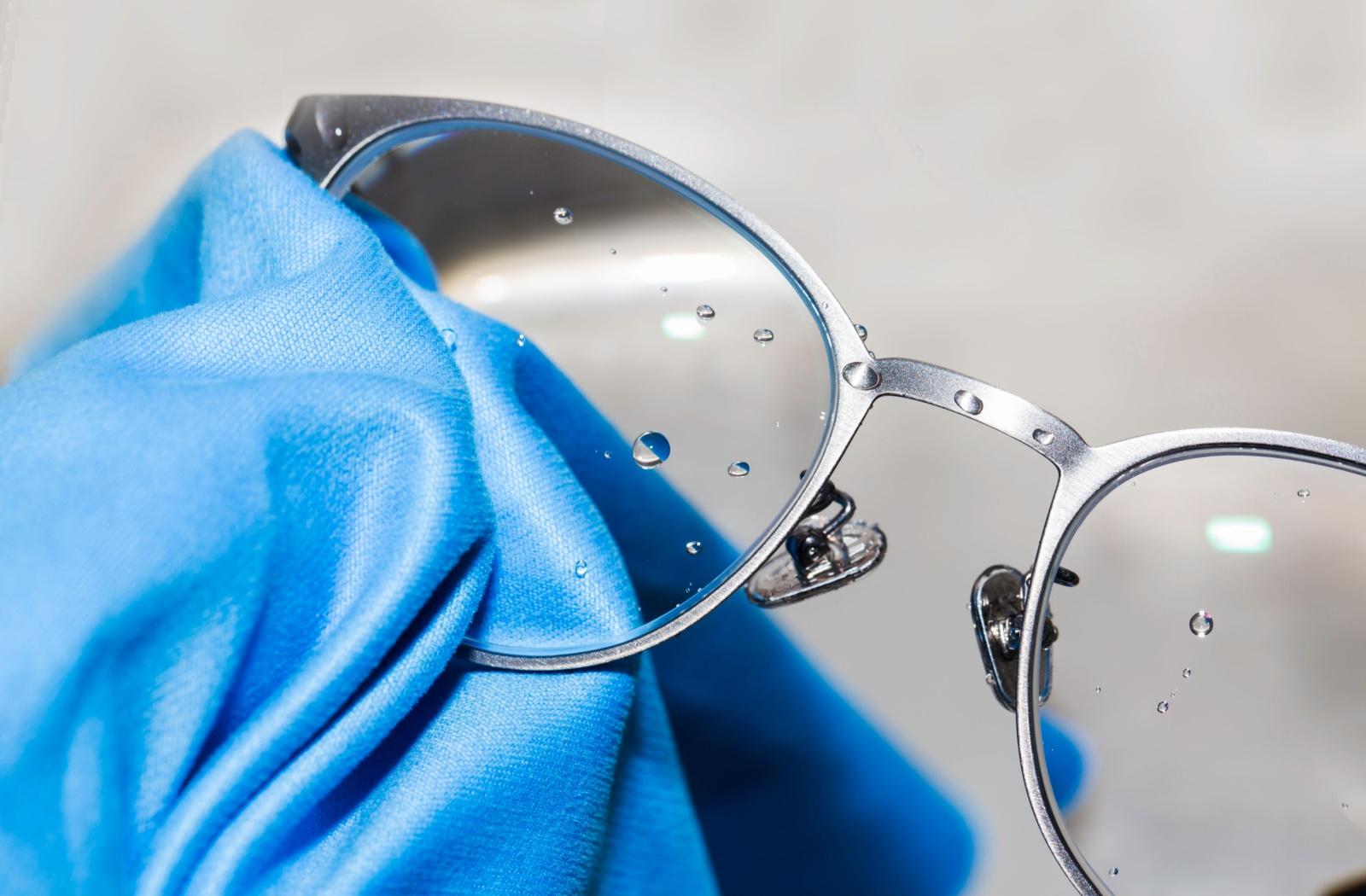 A close up of glasses being cleaned with the appropriate solution and cloth.